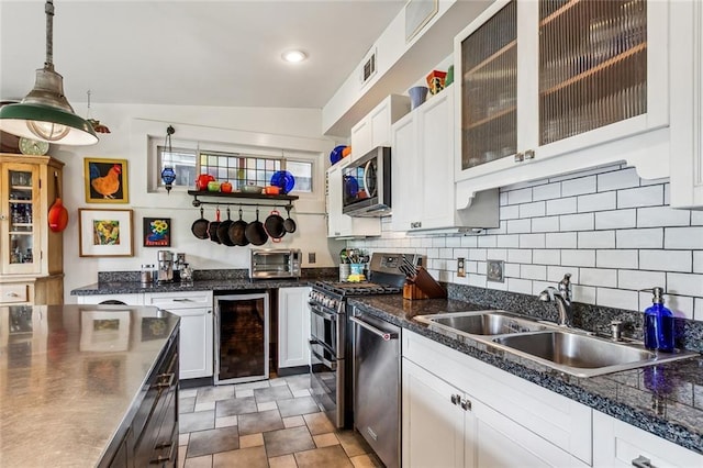 kitchen featuring stainless steel appliances, beverage cooler, a sink, and tasteful backsplash