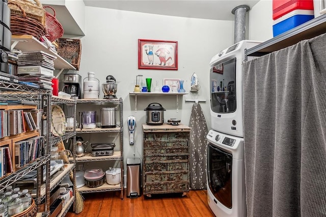 kitchen with stacked washer and clothes dryer and wood finished floors