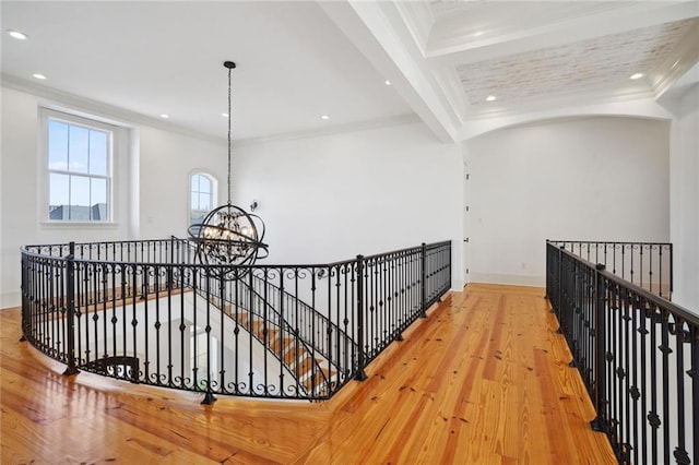 hall with a chandelier, an upstairs landing, crown molding, and hardwood / wood-style flooring