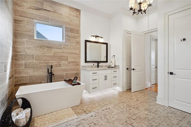 bathroom with a freestanding bath, a chandelier, and vanity