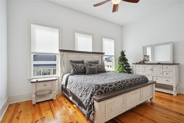 bedroom featuring baseboards, ceiling fan, and light wood finished floors