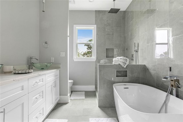 full bathroom with separate shower and tub, vanity, tile walls, tile patterned flooring, and toilet