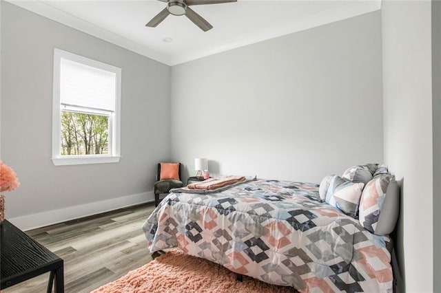 bedroom featuring ceiling fan, light hardwood / wood-style flooring, and crown molding