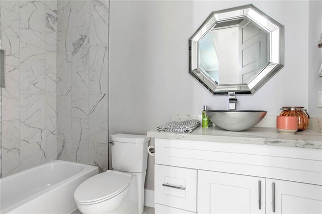 full bathroom with tiled shower / bath, vanity, and toilet