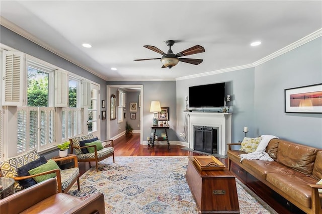 living room with crown molding, ceiling fan, and wood-type flooring