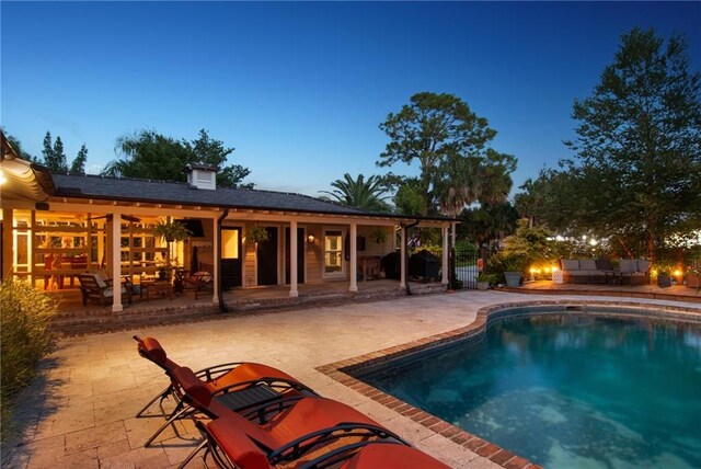 pool at dusk with a patio