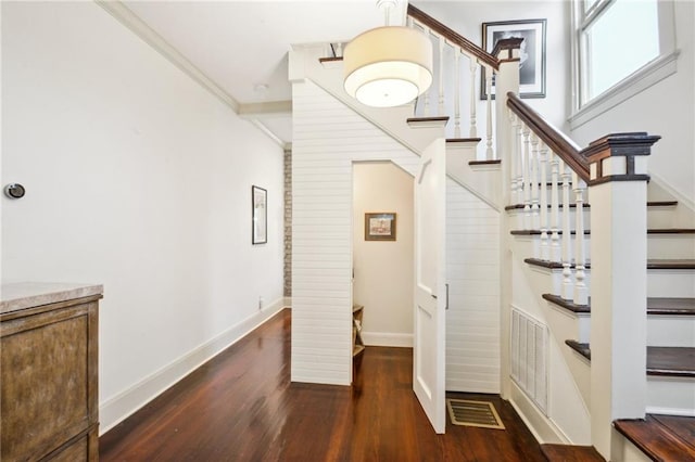 staircase with hardwood / wood-style flooring and ornamental molding