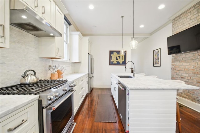 kitchen featuring a kitchen breakfast bar, a center island with sink, dark hardwood / wood-style floors, appliances with stainless steel finishes, and white cabinetry