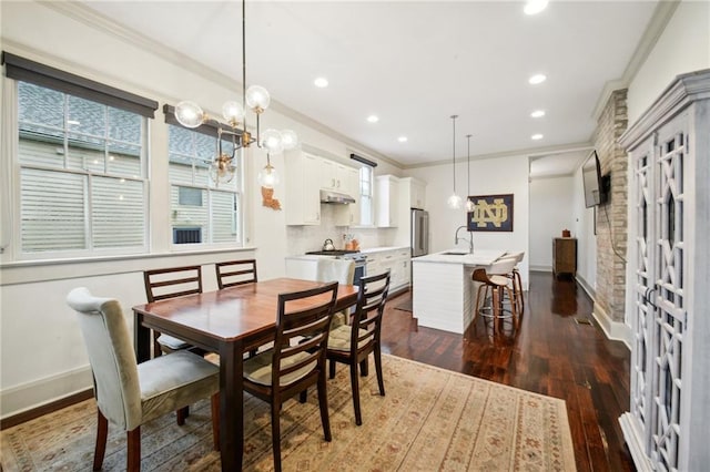 dining area featuring a notable chandelier, ornamental molding, dark hardwood / wood-style floors, and sink