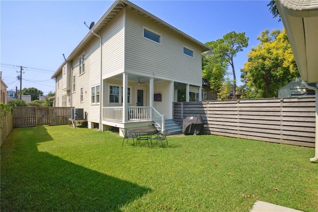 back of property with central AC, a lawn, and ceiling fan