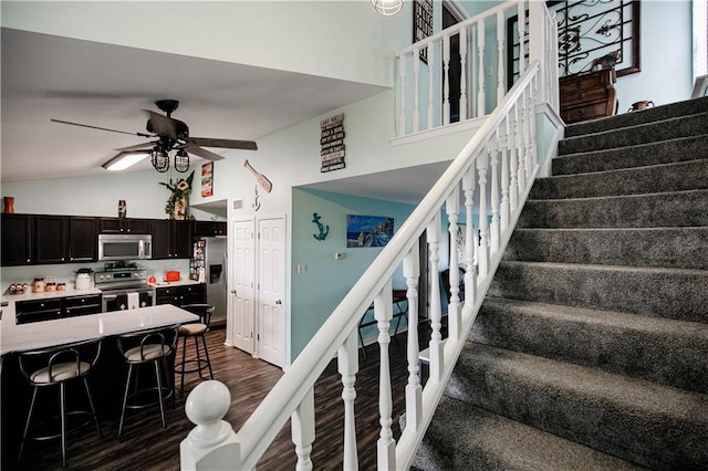 staircase with high vaulted ceiling, wood-type flooring, and ceiling fan