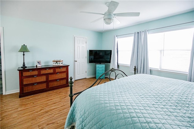 bedroom with multiple windows, light wood-type flooring, and ceiling fan