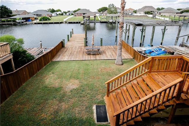 view of dock with a yard and a water view