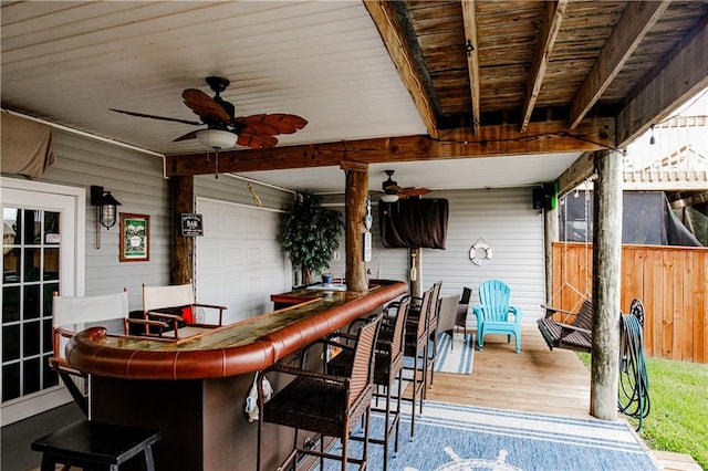 wooden deck with an outdoor bar and ceiling fan