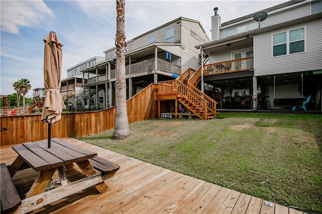 rear view of house featuring a deck and a lawn