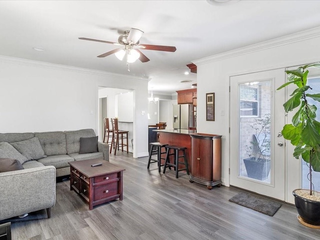 living room with crown molding, hardwood / wood-style floors, and ceiling fan