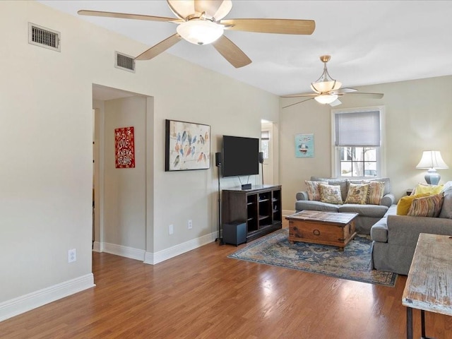 living room featuring ceiling fan and dark hardwood / wood-style floors