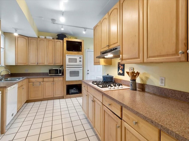 kitchen featuring light brown cabinetry, sink, and white appliances