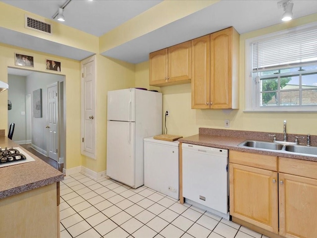 kitchen featuring light brown cabinets, rail lighting, white appliances, sink, and light tile patterned flooring