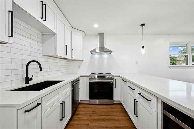 kitchen featuring white cabinets, sink, wall chimney range hood, appliances with stainless steel finishes, and dark hardwood / wood-style flooring