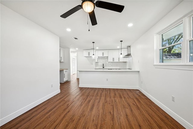 unfurnished living room featuring ceiling fan, sink, and dark hardwood / wood-style flooring