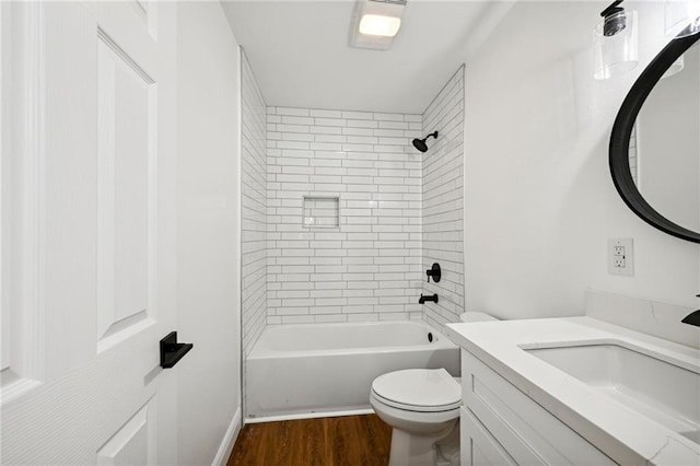 full bathroom featuring tiled shower / bath combo, hardwood / wood-style floors, vanity, and toilet