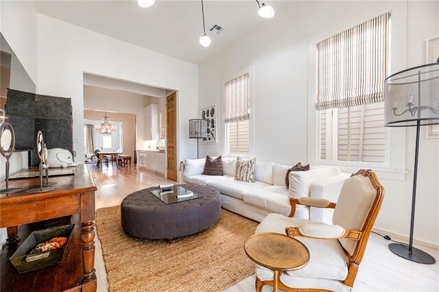 living room with a chandelier and light wood-type flooring