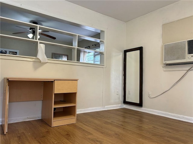 unfurnished bedroom featuring an AC wall unit and hardwood / wood-style flooring