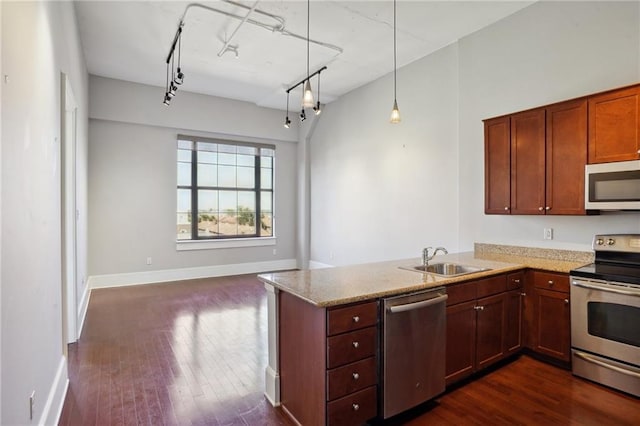 kitchen featuring kitchen peninsula, pendant lighting, sink, and stainless steel appliances