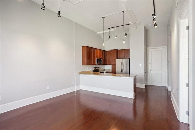 kitchen featuring kitchen peninsula, high vaulted ceiling, rail lighting, stainless steel appliances, and dark hardwood / wood-style floors