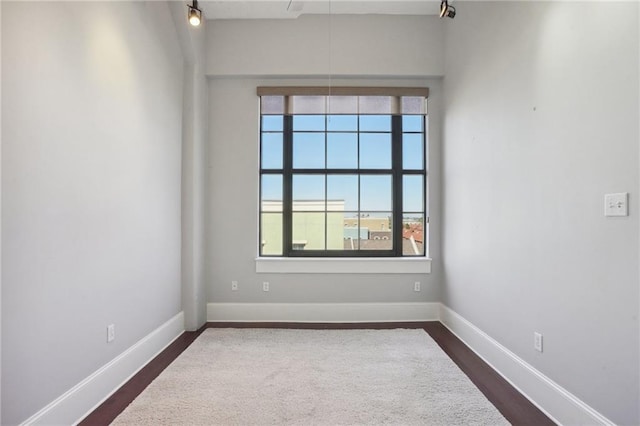 spare room featuring dark hardwood / wood-style flooring and a wealth of natural light