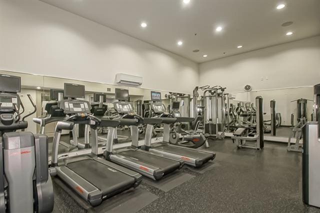 workout area featuring an AC wall unit and a high ceiling