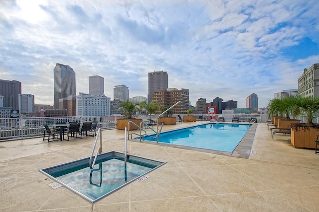 view of swimming pool featuring a patio and a hot tub