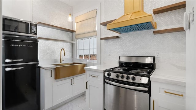 kitchen with sink, custom exhaust hood, backsplash, white cabinets, and appliances with stainless steel finishes