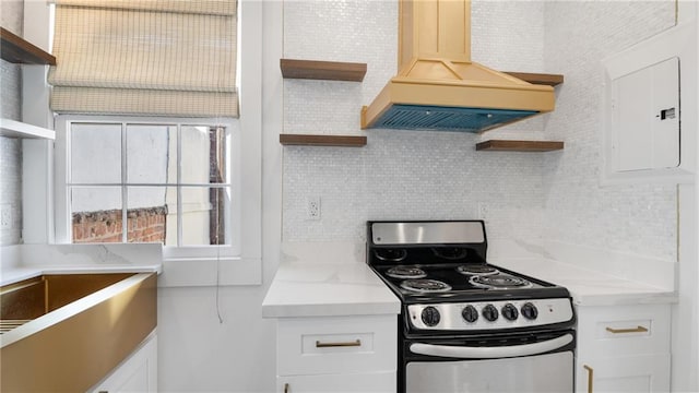 kitchen with white cabinets, premium range hood, and stainless steel electric range