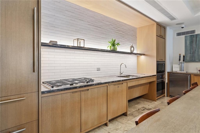 kitchen with backsplash, appliances with stainless steel finishes, sink, and light tile patterned floors