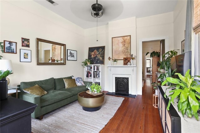 living room with ceiling fan and dark wood-type flooring