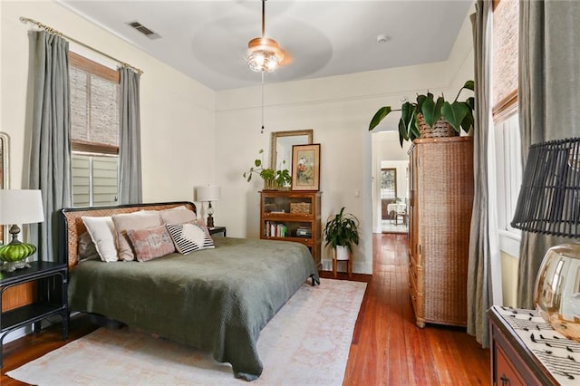 bedroom with hardwood / wood-style flooring, multiple windows, and ceiling fan