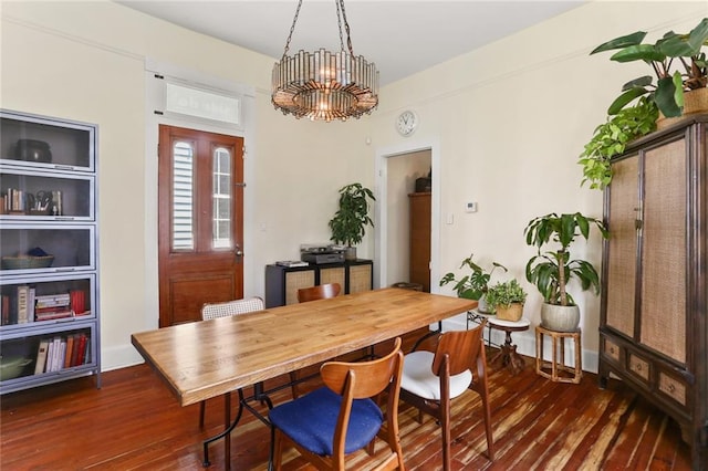 dining area featuring a chandelier and dark wood-type flooring