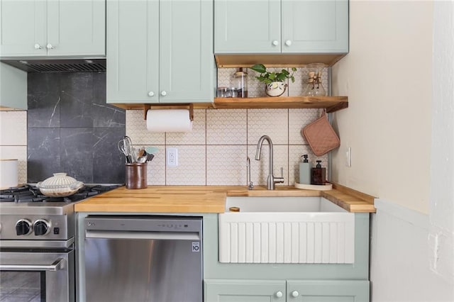 kitchen with sink, butcher block counters, stainless steel appliances, backsplash, and exhaust hood