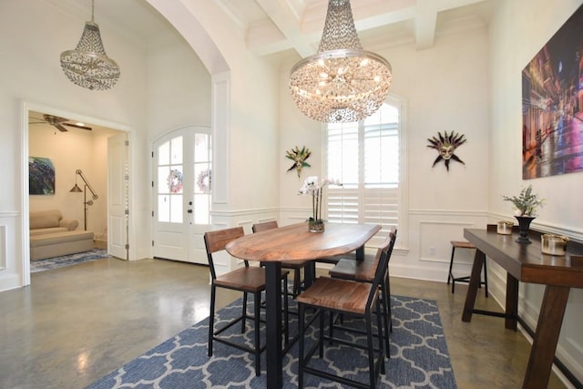 dining area with coffered ceiling, ceiling fan with notable chandelier, and beam ceiling