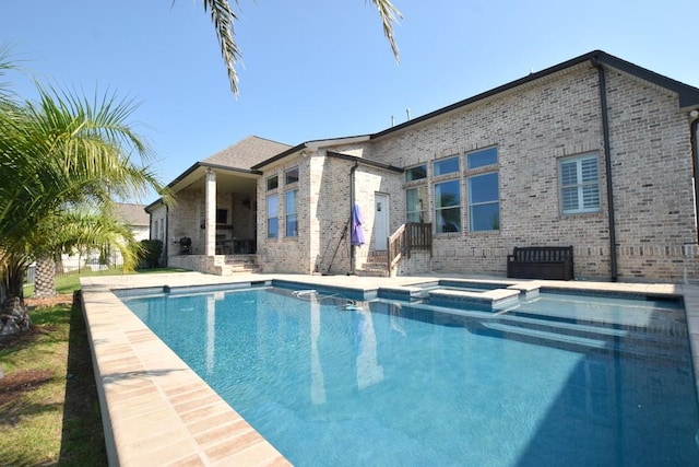 back of property with a swimming pool with hot tub