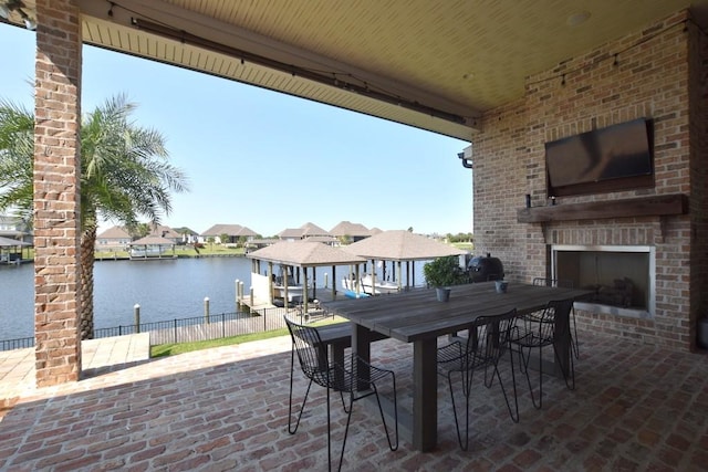 view of patio / terrace with a water view and an outdoor brick fireplace