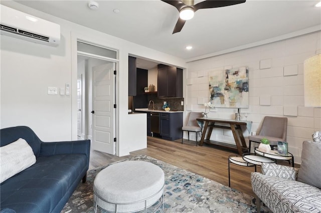 living room with wood-type flooring, ceiling fan, and a wall mounted AC