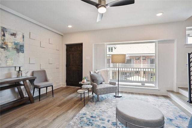 sitting room with wood-type flooring and ceiling fan