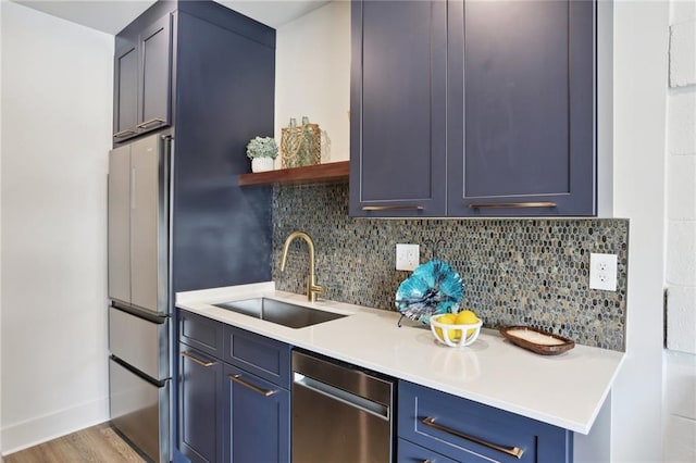 kitchen with sink, light hardwood / wood-style flooring, backsplash, blue cabinetry, and stainless steel appliances