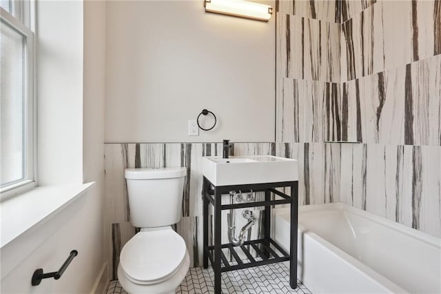 bathroom featuring tile patterned flooring, tile walls, and toilet