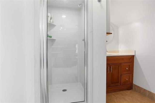 bathroom featuring vanity, tile patterned flooring, and a shower with door