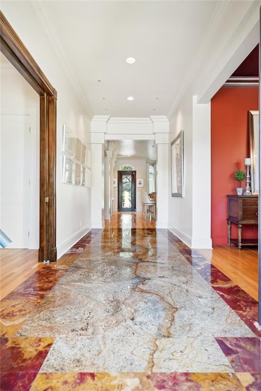 interior space featuring ornate columns, hardwood / wood-style flooring, and ornamental molding