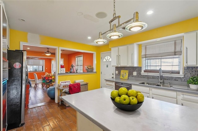 kitchen with sink, tasteful backsplash, dark wood-type flooring, white cabinetry, and appliances with stainless steel finishes